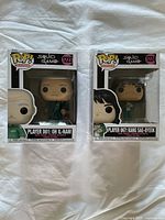 Front view of two Funko Pop! Squid Game figures in original boxes showing Player 001 and Player 067 characters.
