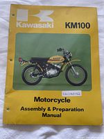 Front cover of Kawasaki KM100 Assembly & Preparation Manual showing motorcycle image and manual title.