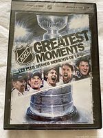 Front cover of NHL Greatest Moments DVD showing Stanley Cup and NHL players