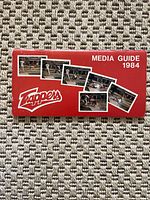 Front cover of the 1984 Edmonton Trappers Media Guide, showing the red cover with team logo and action photos from games.