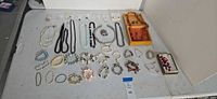 Overview of entire lot laid out on table showing necklaces, bracelets, earrings, two boxes
