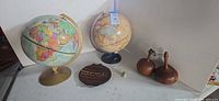 Full lot view showing both globes, wooden trivet, pair wood clubs and frog
