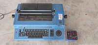 Top view of blue IBM electric typewriter with ribbon box