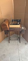 Full view of sewing machine mounted on cabinet and treadle base