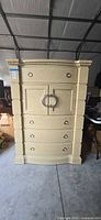 Front view of tall cream painted chest with cabinet and drawers