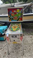 Front view showing entire pinball machine with backbox raised