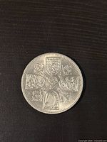 Reverse of the coin depicting British heraldic shields arranged around a cross
