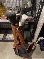 Golf bag containing golf clubs with numbered plush club head covers (1,3,5) and shoulder strap.