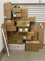 Stack of 21 cardboard boxes of various sizes containing lighting fixtures, mostly new or like new condition.