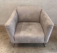 Front view of grey Natuzzi Regia armchair showing boxy upholstery and straight arms