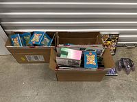 View of large box showing multiple binders or folders with Pokemon cards inside blue sleeves and additional card packs.