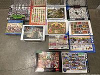 12 puzzle boxes arranged on floor showing various artwork and identifying brands and themes.