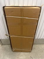 Cardboard packaging box of the treadmill walking pad showing intact sealing tape and moderate shelf wear.