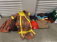 Photo of folded vintage clothes including yellow brown dress, red bag and beige shawl.