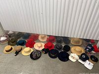 Full view of all hats in the collection laid out on the floor showing various types including wool fedoras, straw hats, baseball caps, and felt hats.