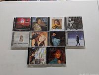 Photo of 10 assorted music CDs in jewel cases featuring various country artists and album covers.