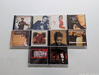 Photo showing 10 CDs in jewel cases laid out in two rows of five. Albums include Harry Connick Jr., Collin Raye, Eurythmics, Natalie Cole, Sarah Jones, and others.
