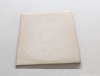 Front view of original white cover for The Beatles White Album, visible wear and discoloration.