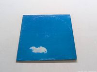 Front cover of the LP sleeve in blue with a small white cloud shape near bottom.