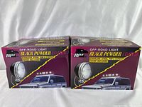 Two boxed Eagle Eye off-road light housings, black powder coated, showing the packaging and included protective covers.