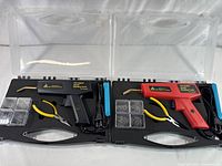 Both plastic welding kits side by side in their open carrying cases showing contents.