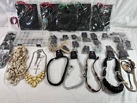 Wide view showing a variety of over 30 Paparazzi brand necklaces in different styles arranged on a white surface. Includes natural shell necklaces, braided leather cord styles, metallic chains, and bead combinations with original retail tags and plastic bags.