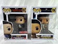 Front view of boxed Funko Pop figures of Katy and Gilgamesh, showing original sealed packaging with Target exclusive sticker on Katy box.