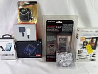 7 small electronics items grouped including game console, rechargeable battery, headset, microphone, phone light