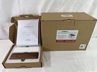 Opened box showing wooden night lamp, manual and foam packaging insert.