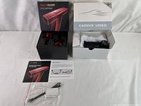 Full view of Torchbeam LED headlight kit box with two red LED bulbs inside, next to the boxed full HD dual dash cam system, along with manual and installation accessories.