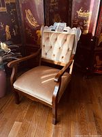 Full view of antique Eastlake style wooden arm chair with beige upholstery showing overall condition and style.
