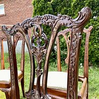 Close-up view of carved back splat and crest rail showing detailed acanthus leaf and scroll carvings