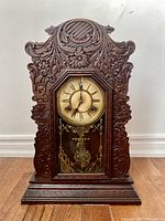 Front view of the antique Waterbury mantel clock showcasing detailed oak wood carvings and clock face.