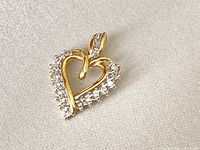 Front view of heart-shaped pendant showing diamond-set outer edge and bail.
