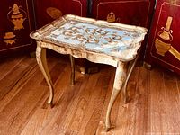Full view of the small gilted Florentine end table showing four curvy Louis XV style legs and scalloped edges.