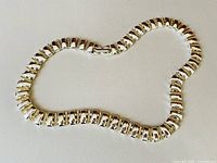 Full view of the necklace laid flat, showing the linked rectangular shape and clasp.