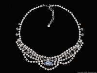 Full view of the vintage rhinestone necklace laid flat showing its design and structure on black background.