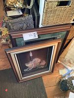 Two 3D framed shadow box pictures leaning against a wall, showing the full frame and depth.