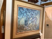 Framed artwork showing a deer and fawn under a large tree with a 3D effect behind glass in a tan frame.