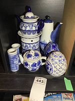 Overview of all items showing two teapots, one with warmer, two vases, and two decorative eggs, all in blue and white ceramic.
