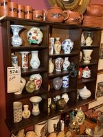 Wooden shelf with 18-inch width and 22-inch height filled with various small decorative vases and figurines