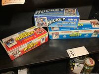 Three boxes of NHL hockey cards shown, two Score 1991 Collector Sets and one factory sealed O-Pee-Chee 1991-92 Complete Card Set.