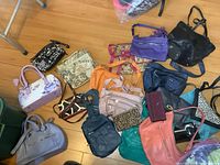 Top view of all purses scattered on floor including wallet and bow tie