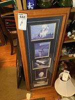 Full image of the frame showing all five wildlife prints and wood frame with blue matte inside.