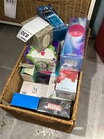 Basket filled with multiple sealed perfume boxes of various brands and fragrances.