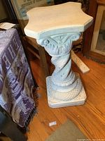 Full view of the pedestal showing white plaster material and octagonal top shape.