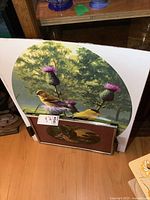 Large unframed decorative print featuring two yellow birds on a thistle plant with green trees background.
