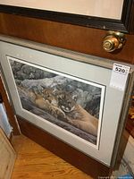 Full view of the framed print showing two lying cougars against a rocky backdrop.