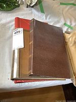 Photo of three stamp albums stacked, showing brown, red, and transparent covers