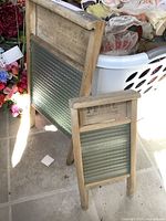 Photo of two wooden washboards standing on tiled floor, showing textured glass centers and aged wood frames.